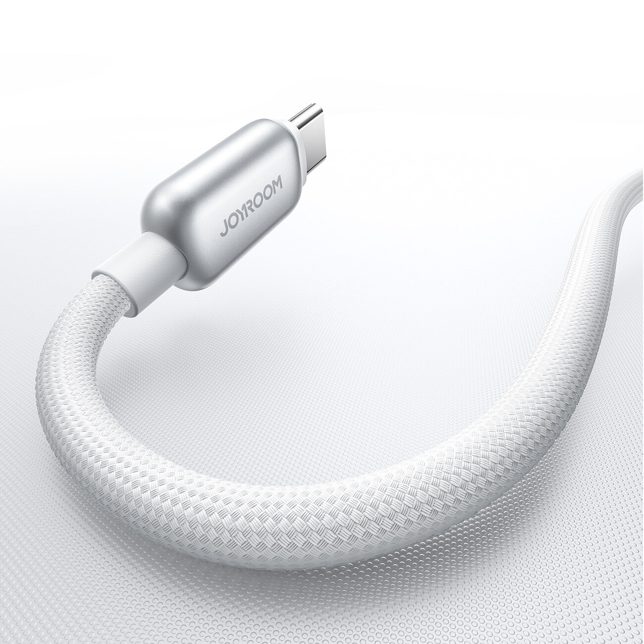Na obrazie widoczny jest biały kabel z plecioną osłoną i metaliczną końcówką z napisem \'JOYROOM\'.