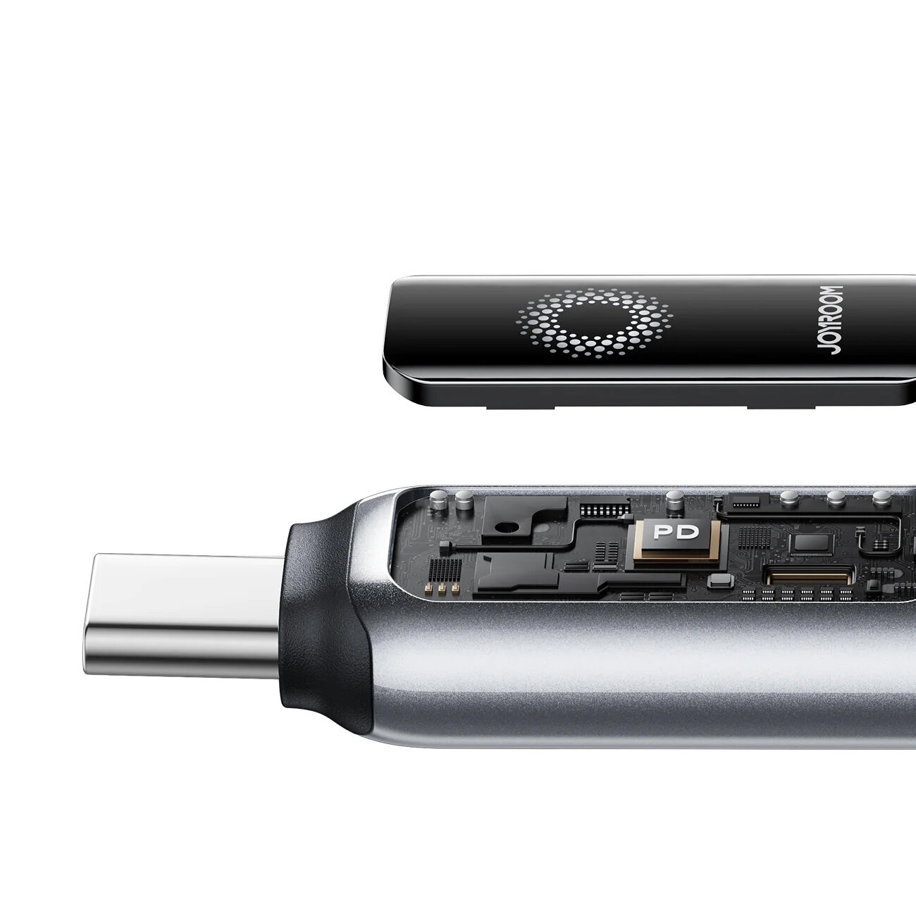 Obraz przedstawia zbliżenie na końcówkę kabla USB-C z widocznym wnętrzem, gdzie znajduje się oznaczenie \'PD\'. Obok znajduje się czarny element z logo \'JOYROOM\'.