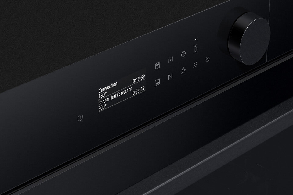 Czarny panel piekarnika z wyświetlaczem pokazującym tryby \'Convection\' i \'Bottom Heat Convection\' oraz temperatury 180° i 200°. Obok wyświetlacza znajdują się przyciski dotykowe i pokrętło.