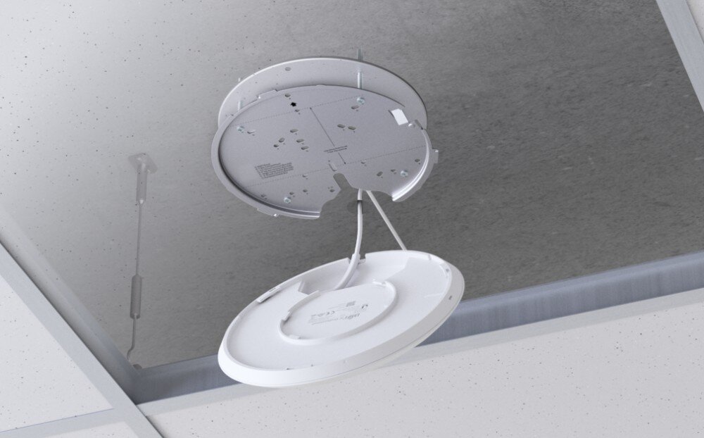 Punkt dostępu UBIQUITI UAP-AC-LR Widok od dołu na proces instalacji białego okrągłego urządzenia sieciowego zawieszonego na przewodzie pod metalowym uchwytem sufitowym