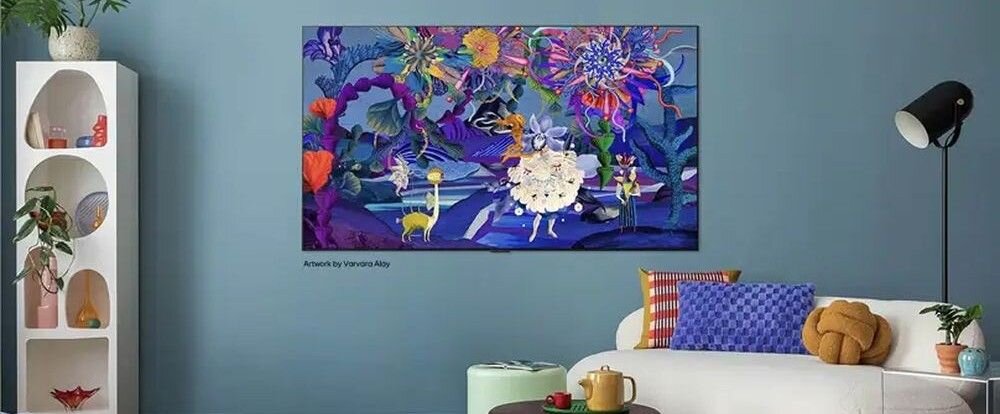 Na ścianie wisi telewizor wyświetlający kolorową grafikę z motywem kwiatowym i postaciami. W pokoju znajduje się biała sofa z kolorowymi poduszkami, lampa stojąca oraz półka z dekoracjami.