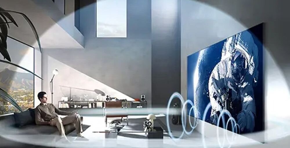 LG 55MRGB86B6A Dolby Atmos 360 audio przestrzenny dźwięk kino domowe, osoba siedzaca na kanapie oglądająca telewizję