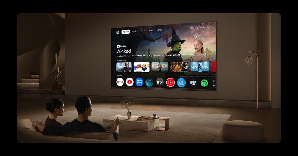 Telewizor TCL 98P8L Google TV aplikacje streaming rekomendacje, osoba oglądająca mecz w telewizji otoczona dżwiękiem