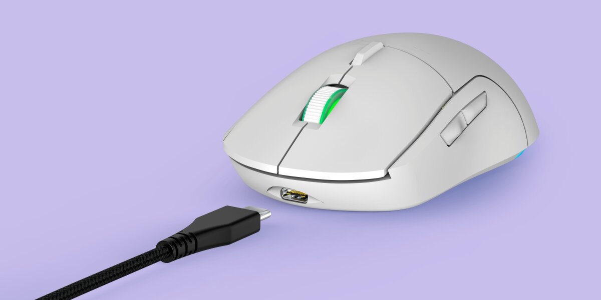 Biała mysz komputerowa z zielonym podświetleniem na rolce, obok której znajduje się odłączony kabel USB. Mysz ma ergonomiczny kształt i dodatkowe przyciski boczne.