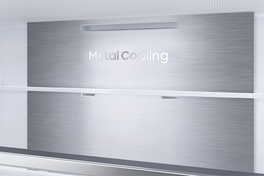 Wnętrze lodówki z metalową ścianą z napisem \'Metal Cooling\'. Widoczne są półki i otwory wentylacyjne.
