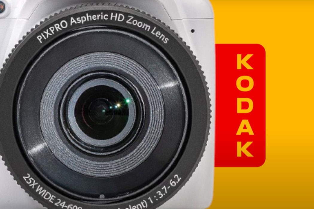 Obraz przedstawia zbliżenie na obiektyw aparatu z napisem \'PIXPRO Aspheric HD Zoom Lens\'. Obok widoczne jest czerwone logo z napisem \'KODAK\' na żółtym tle.