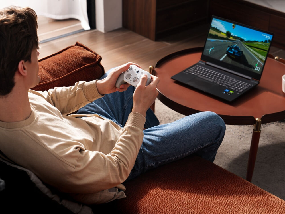 Kontroler GAMESIR G7 Pro Tri-Mode Czarny
                mężczyzna na kanapie naprzeciwko laptopa z kontrolerem w ręku połączenie xbox pc android 2.4g przewodowe bluetooth zaczep przewodu