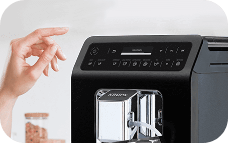 Ekspres do kawy z panelem dotykowym, na którym widoczny jest napis \'Macchiato\'. Na obudowie znajduje się logo \'KRUPS\'.