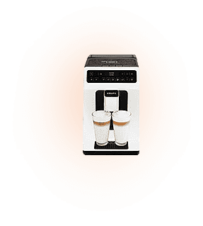 Ekspres do kawy z dwoma szklankami wypełnionymi napojem, umieszczony na pomarańczowym tle. Na górze widoczne jest logo \'KRUPS\'.