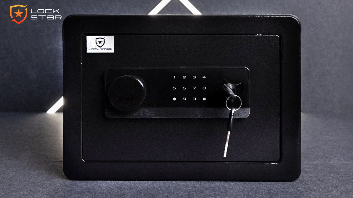 Czarny sejf elektroniczny z klawiaturą numeryczną i kluczem w zamku. Logo \'LOCK STAR\' widoczne w lewym górnym rogu.