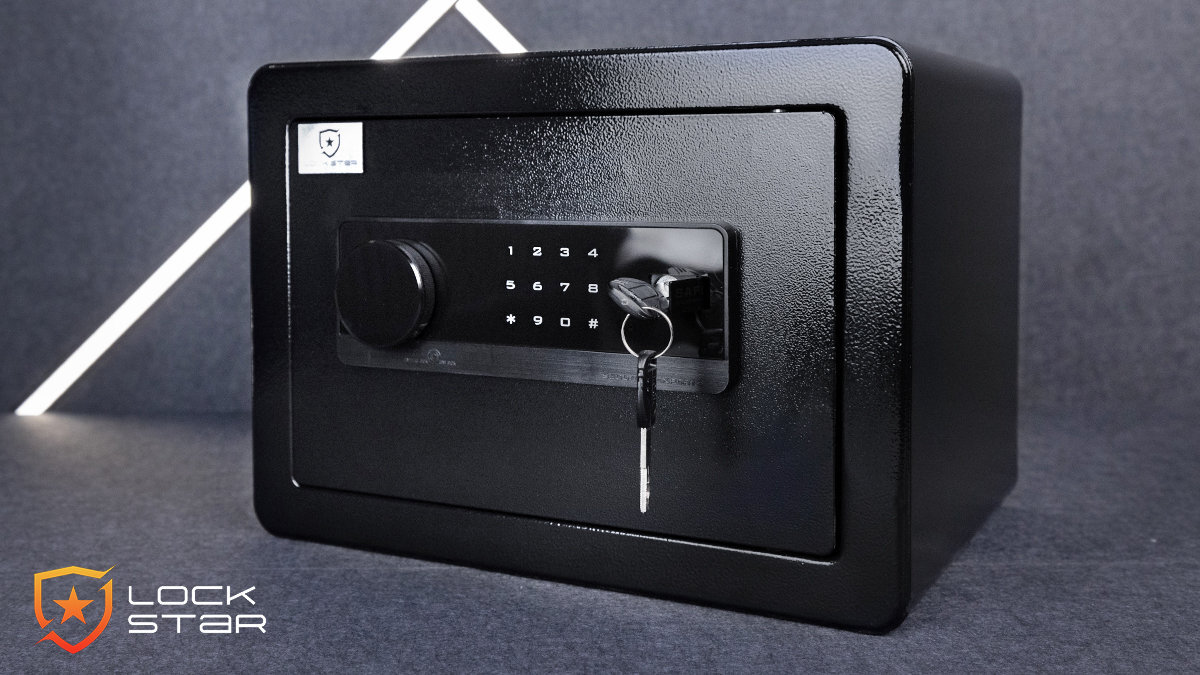 Czarny sejf elektroniczny z klawiaturą numeryczną i kluczem w zamku. Logo Lock Star widoczne w lewym dolnym rogu.