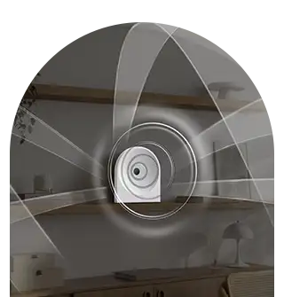 dolby atmos-ls51h 320x335 Obraz przedstawia biały głośnik z efektem wizualnym fal dźwiękowych rozchodzących się wokół niego. W tle widoczna jest półka z dekoracjami i lampka na biurku.