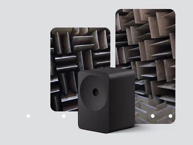 2026-hw-ls70h-samsung-audio-lab 664x498 Na obrazie widoczny jest czarny głośnik o prostokątnym kształcie, umieszczony na tle dwóch paneli z materiałem dźwiękochłonnym. Panele mają strukturę przypominającą ostre, trójwymiarowe kształty.