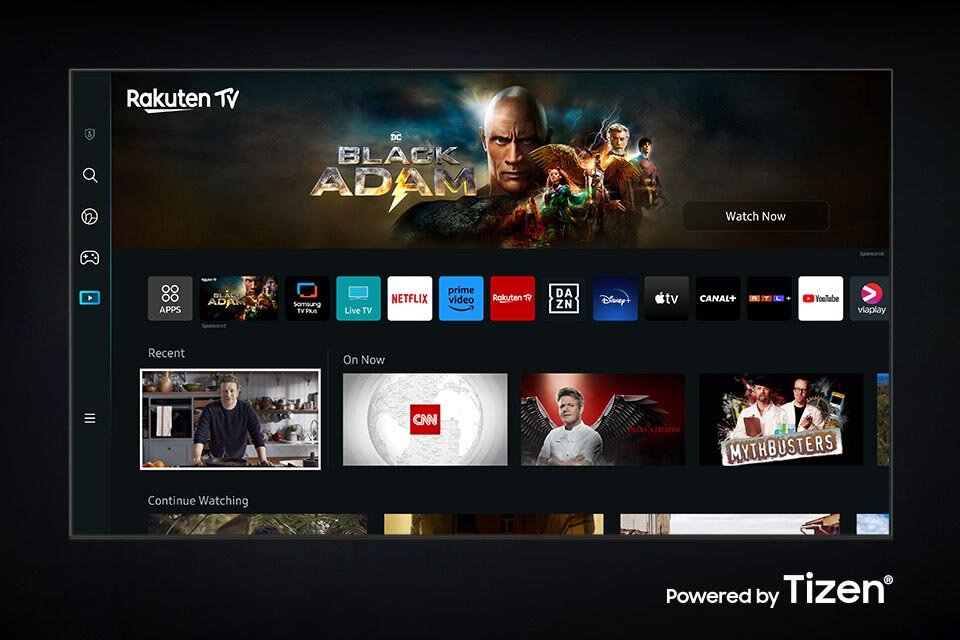 Ekran telewizora z interfejsem Smart TV, na którym widoczne są aplikacje takie jak Netflix, Prime Video, YouTube oraz reklama filmu \'Black Adam\'. W prawym dolnym rogu znajduje się napis \'Powered by Tizen\'.
