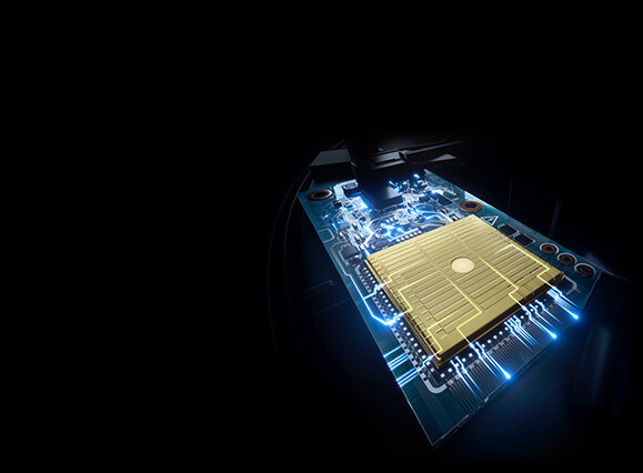 Obraz przedstawia zbliżenie na płytkę drukowaną z widocznymi ścieżkami i elementami elektronicznymi, oświetloną niebieskim światłem. Na środku znajduje się złoty prostokątny element.