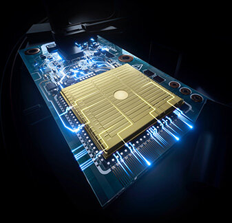 Obraz przedstawia zbliżenie na płytkę drukowaną z centralnie umieszczonym złotym elementem, otoczonym przez świecące niebieskie ścieżki elektryczne. W tle widoczne są ciemne elementy konstrukcyjne.