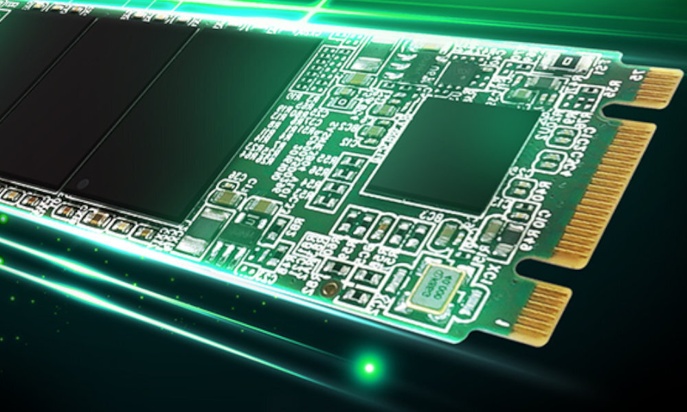 Obraz przedstawia zbliżenie na zieloną płytkę drukowaną dysku SSD z widocznymi elementami elektronicznymi i złotymi złączami. W tle widoczne są zielone, świetliste linie.