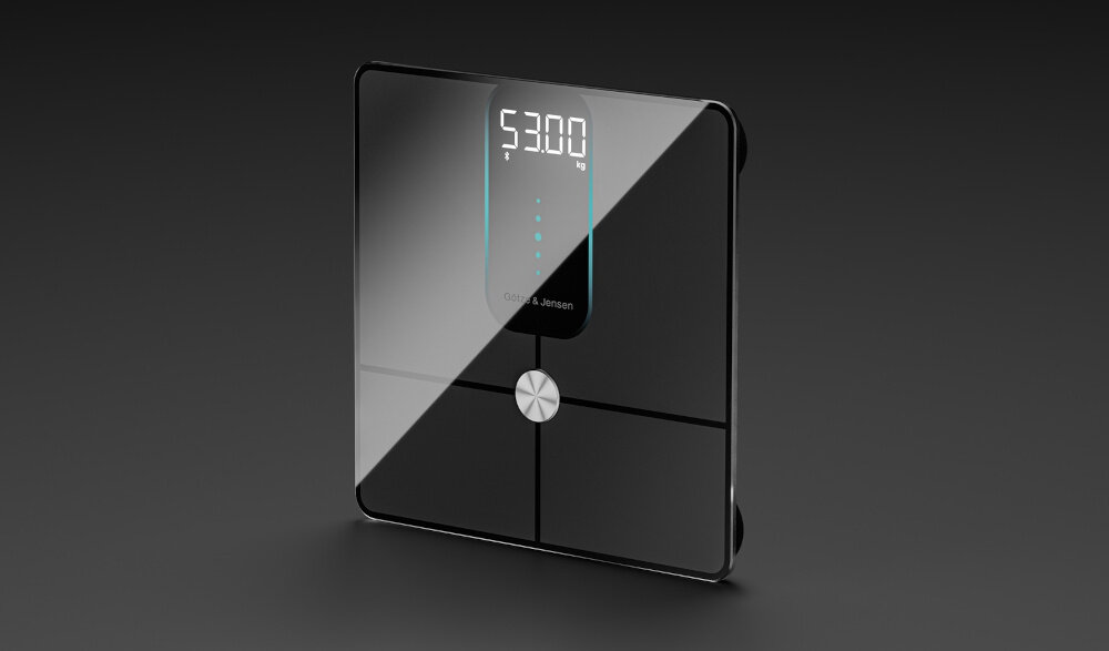 Czarna waga łazienkowa z wyświetlaczem pokazującym \'53.00 kg\'. Na powierzchni widoczne jest logo \'Götze & Jensen\'.