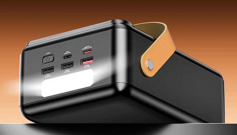 Czarny powerbank z kilkoma portami USB i przyciskiem zasilania, posiada jasne światło LED oraz brązowy uchwyt z boku.