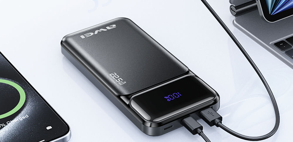 Na obrazie widoczny jest czarny powerbank z logo \'AWEI\' i oznaczeniem \'22.5W\'. Obok powerbanka znajduje się kabel USB podłączony do urządzenia.