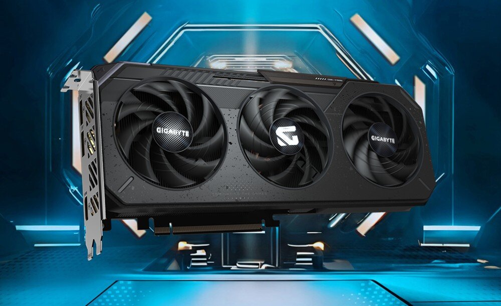 Karta graficzna GIGABYTE Radeon RX 9060XT GAMING OC 16G Widok karty graficznej z trzema wentylatorami umieszczonej na tle futurystycznego, niebieskiego pomieszczenia z podświetleniem i geometrycznymi wzorami, opis