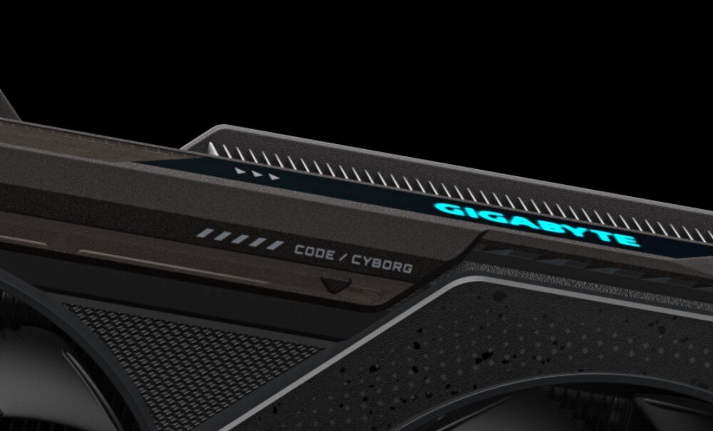 Karta graficzna GIGABYTE Radeon RX 9060XT GAMING OC 16G Fragment obudowy karty z podświetlonym napisem 'GIGABYTE' i oznaczeniem 'CODE / CYBORG' na górnej krawędzi, podświetlenie, kolory, synchronizacja