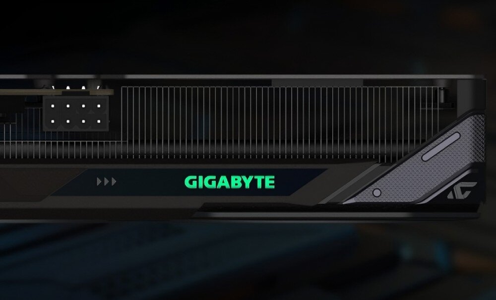 Karta graficzna GIGABYTE Radeon RX 9060XT GAMING OC 16G Górna krawędź karty graficznej z widocznym podświetleniem napisu 'GIGABYTE' oraz fragmentem radiatora, boczna płytka, personalizacja