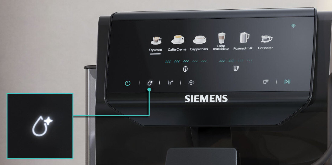 Panel sterowania ekspresu do kawy z wyświetlaczem pokazującym różne opcje napojów, takie jak Espresso, Caffè Crema, Cappuccino, Latte macchiato, Foamed milk i Hot water. Widoczne jest logo \'SIEMENS\' oraz ikony funkcji, w tym symbol kropli z gwiazdką.