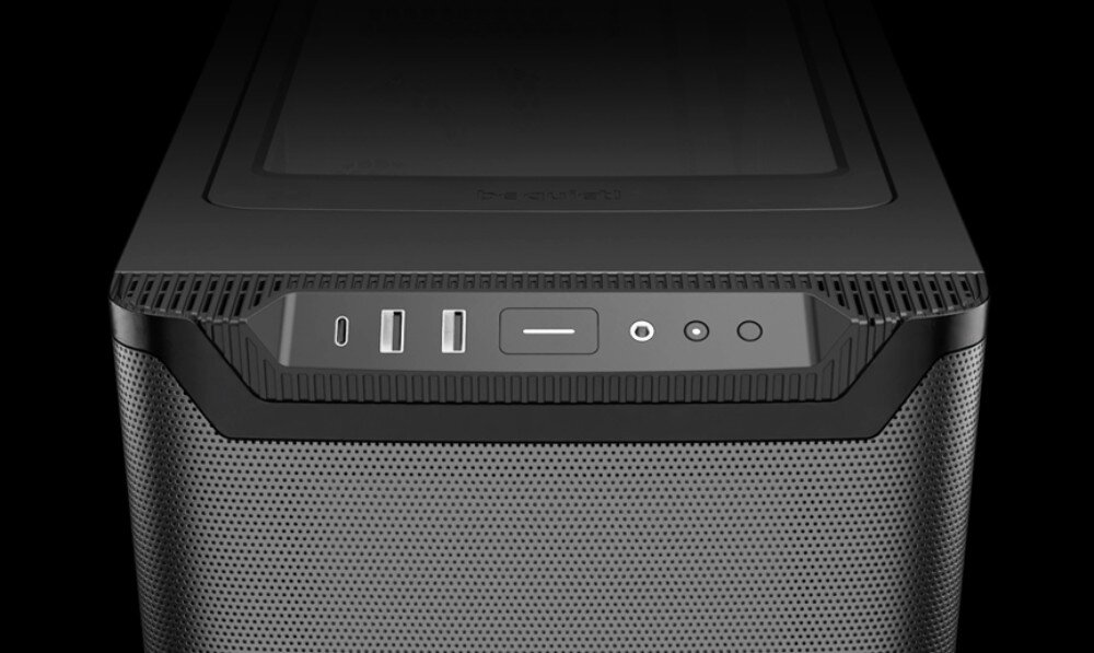 Widok z góry na przedni panel obudowy komputera z portami USB, przyciskiem zasilania i gniazdem audio. Obudowa ma perforowaną powierzchnię i ciemny kolor.
