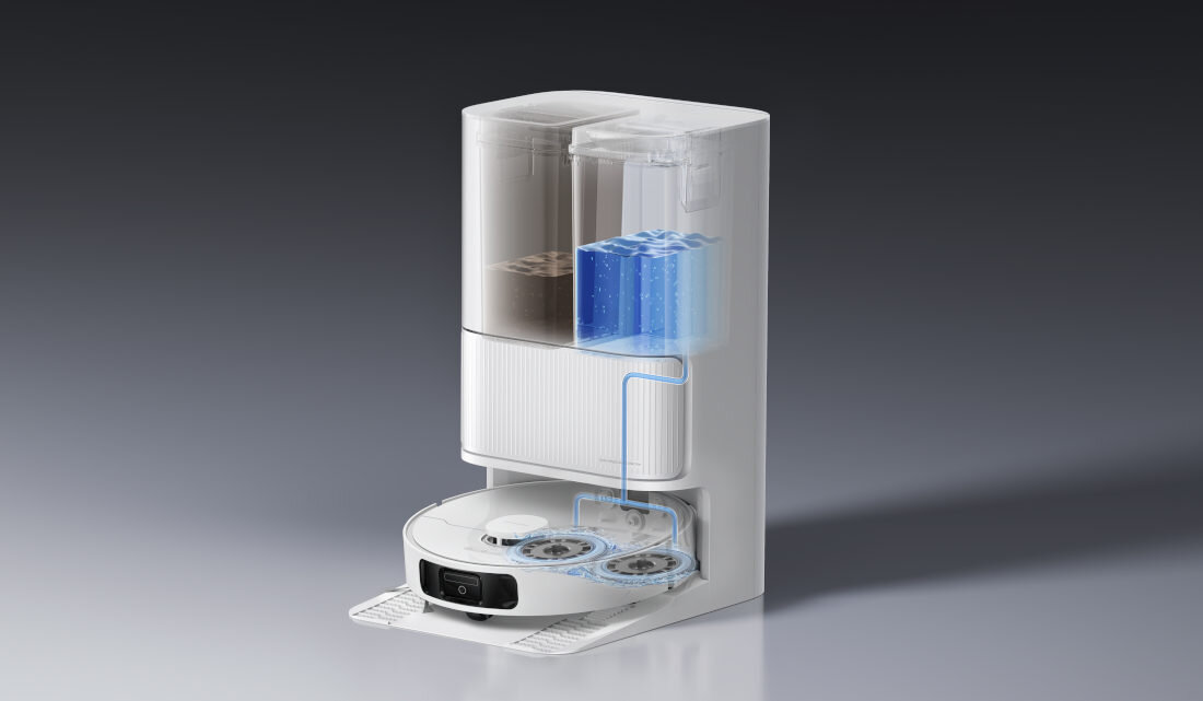 Obraz przedstawia biały robot sprzątający z widocznym systemem pojemników na wodę i odpady. Na górze urządzenia znajdują się przezroczyste pojemniki, a poniżej widoczny jest robot z dwoma okrągłymi szczotkami.