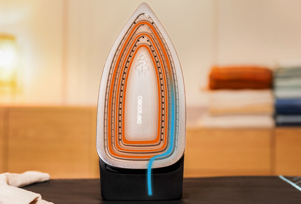 Żelazko ustawione pionowo na podstawce, widoczna stopa z otworami parowymi i logo \'cecotec\'. W tle rozmyte kolory, sugerujące wnętrze z półkami i złożonymi tkaninami.