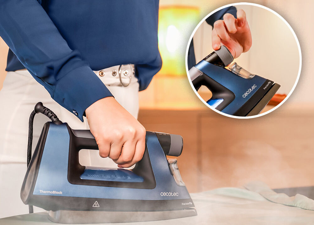 Osoba trzyma żelazko w kolorze niebieskim z widocznym logo \'cecotec\' i napisem \'ThermoBlock\'. W okrągłym zbliżeniu pokazano rękę regulującą pokrętło na żelazku.