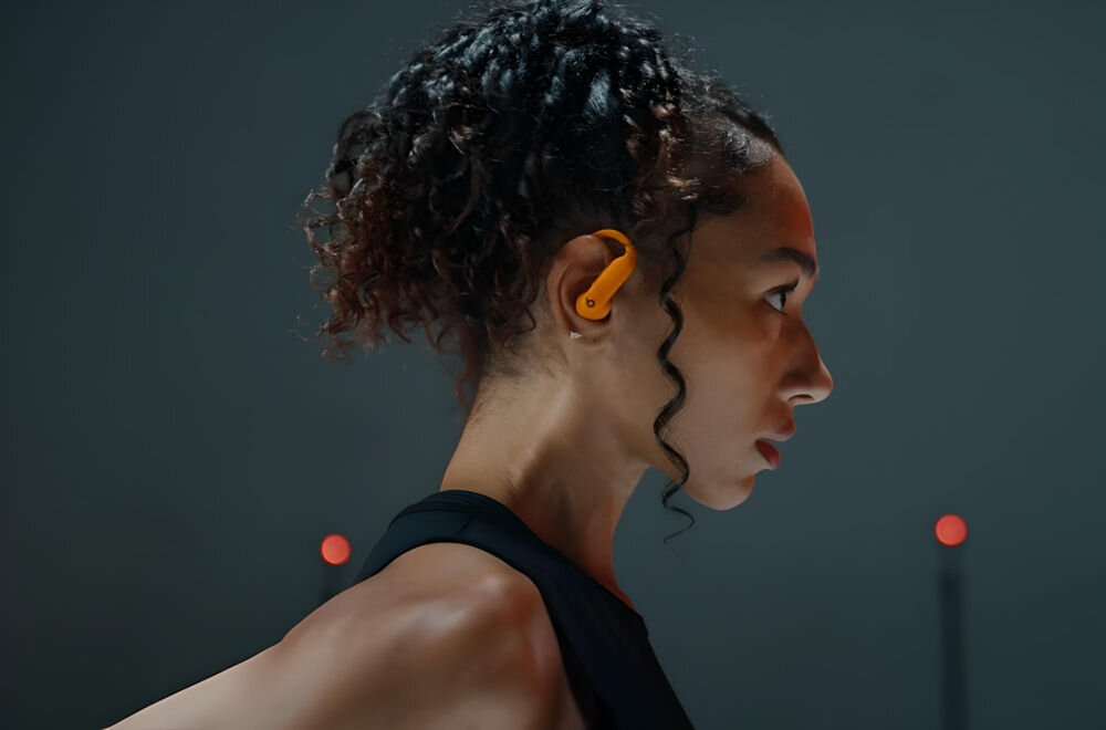 Słuchawki dokanałowe BEATS Powerbeats Pro 2 Piaskowa burza wygoda, trwałość, wysoka jakość dźwięku, sprawdzone przez sportowców, przeszły serię ponad 1500 godzin rygorystycznych testów z 
					udziałem niemal 1000 sportowców, kobieta ze słuchawką w uchu