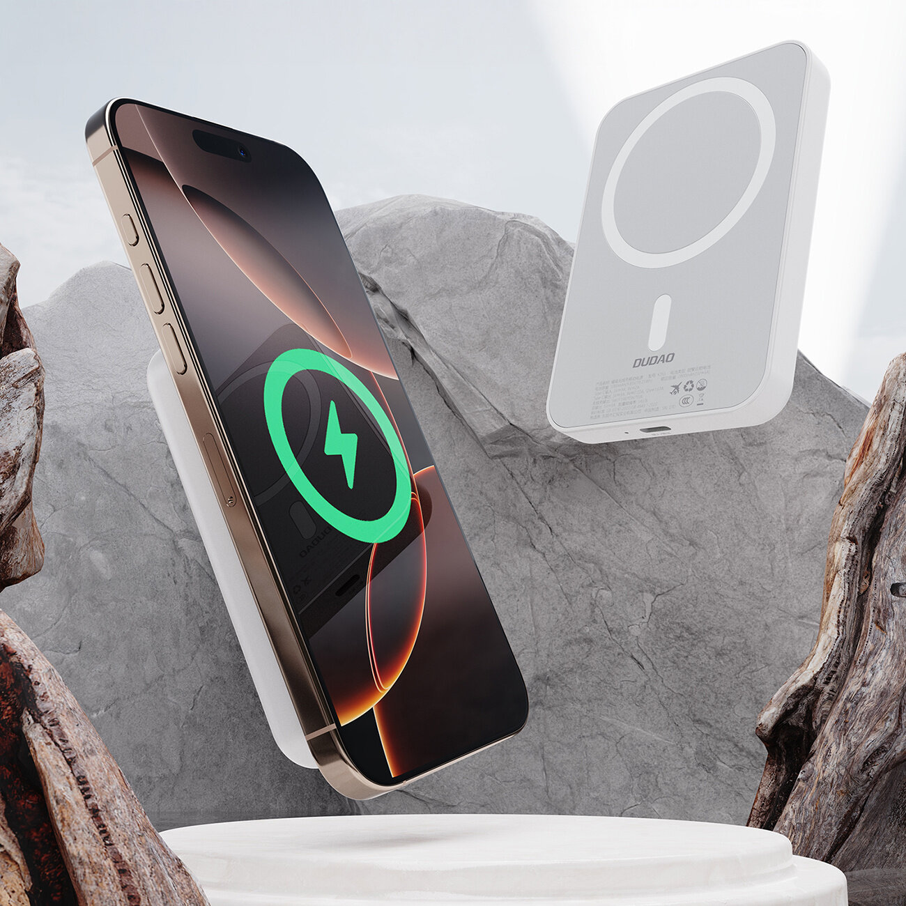 Na obrazie widoczny jest telefon z wyświetlaczem pokazującym ikonę ładowania oraz biały powerbank z napisem \'DUDAO\'. Tło stanowią kamienie i drewno.