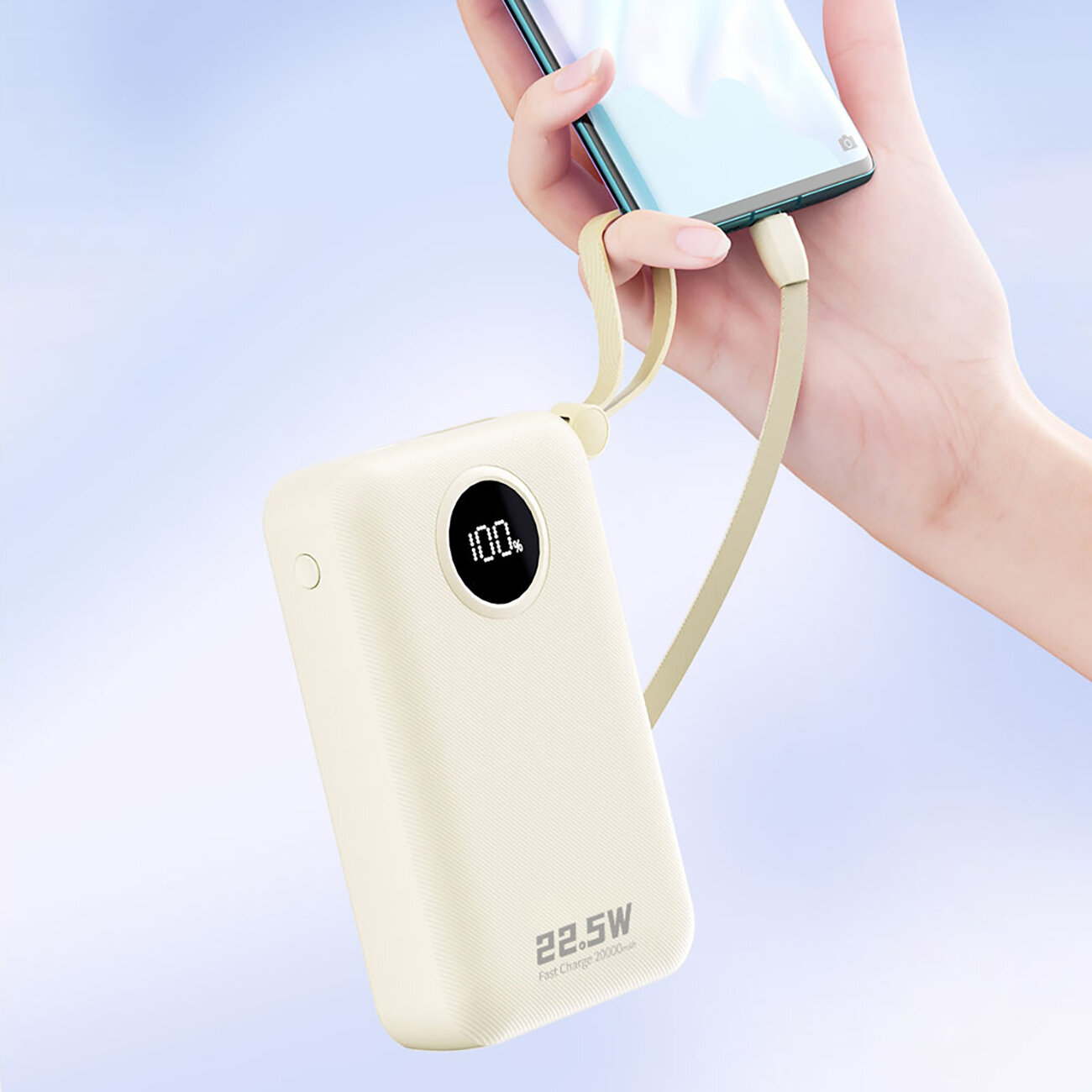 Biały powerbank z wyświetlaczem pokazującym \'100%\' jest podłączony do smartfona za pomocą kabla. Na obudowie widoczny jest napis \'22.5W Fast Charge 20000mAh\'.