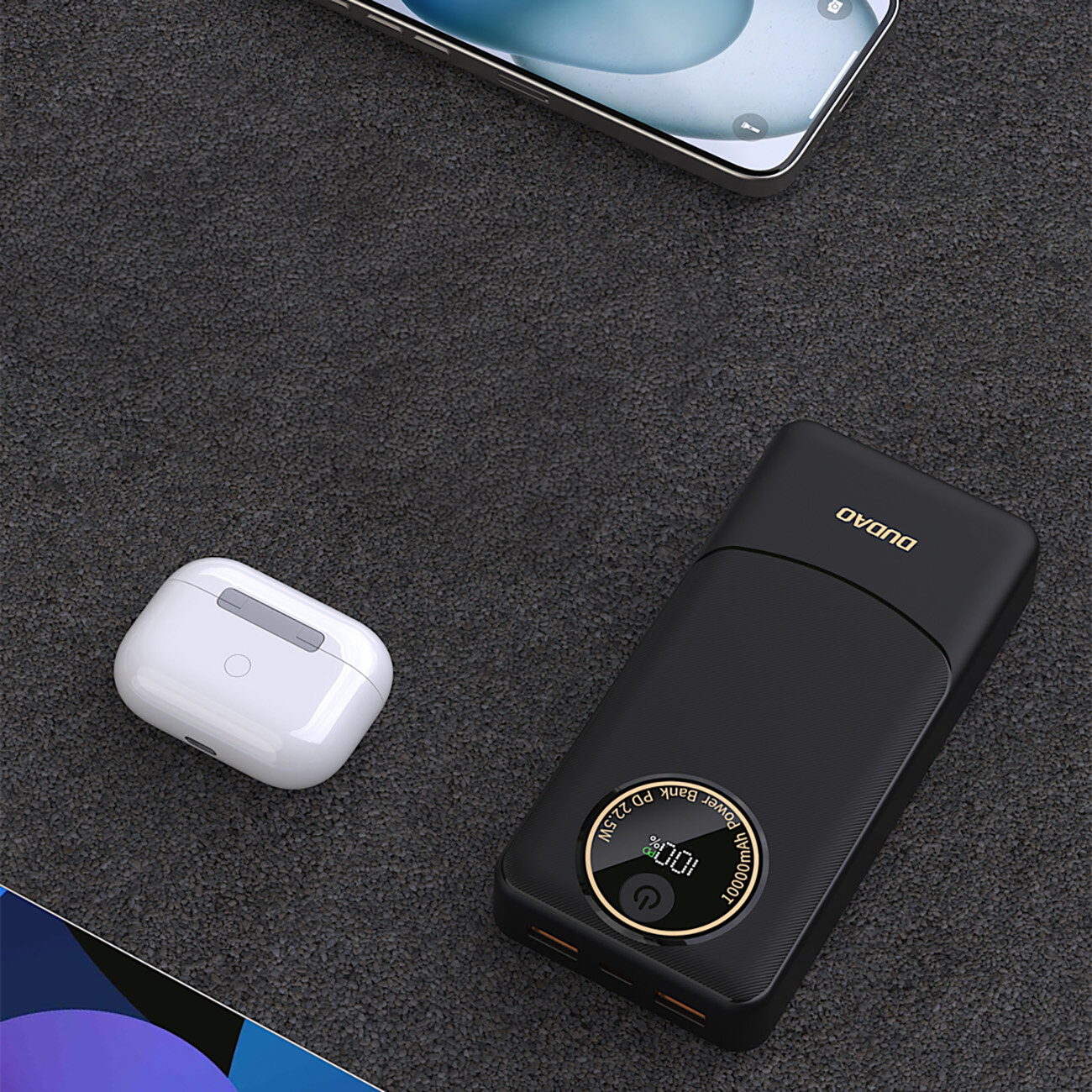 Na ciemnym tle znajduje się czarny powerbank z logo \'DUDAO\' oraz białe etui na słuchawki. Powerbank ma wyświetlacz z napisem \'Power Bank PD 22.5W\'.