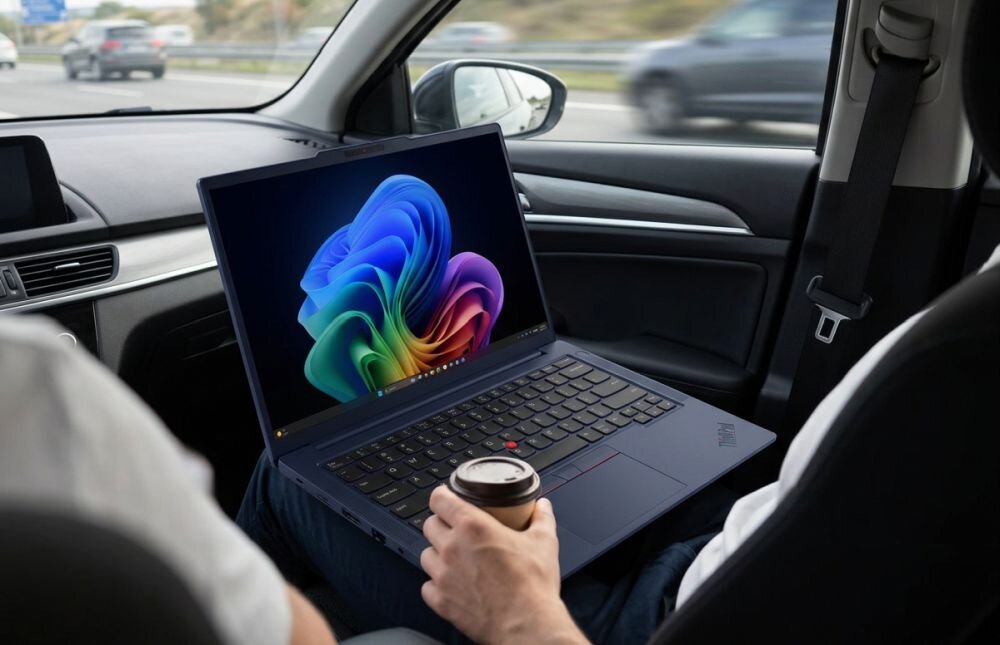 Osoba korzysta z laptopa Lenovo ThinkPad z systemem Windows 11 podczas podróży samochodem i mobilnej pracy biznesowej  