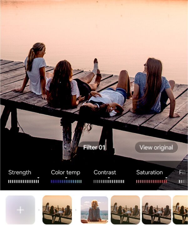 Cztery osoby siedzą na drewnianym pomoście nad wodą o zachodzie słońca. Na dole ekranu widoczne są suwaki do regulacji parametrów obrazu oraz miniatury filtrów z podpisami \'Filter 01\' i \'View original\'.