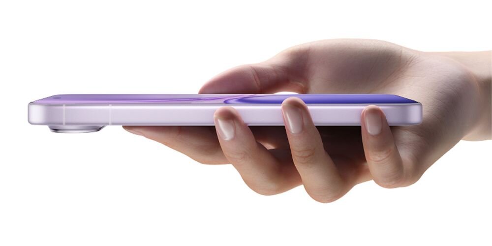 Osoba trzyma w dłoni cienki smartfon o fioletowym kolorze z wystającym obiektywem aparatu.