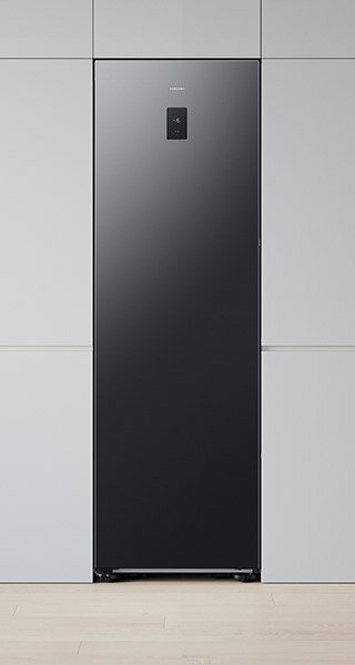 Jednodrzwiowa chłodziarka Samsung RR80H39CCFEO Grafitowa lodówka o nowoczesnym designie z panelem sterowania na drzwiach. Widoczne logo \'SAMSUNG\' na górze urządzenia.