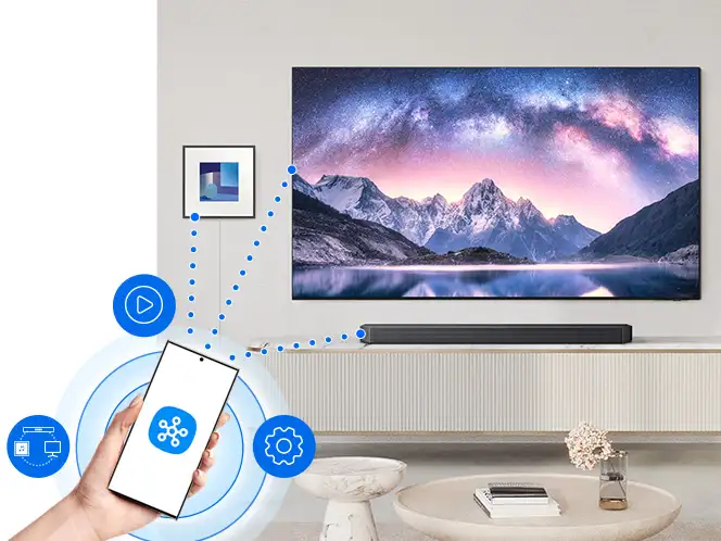 Smartfon z aplikacją SmartThings połączony przez Wi-Fi (Wireless Fidelity) z telewizorem i soundbarem Samsung HW-Q990H.