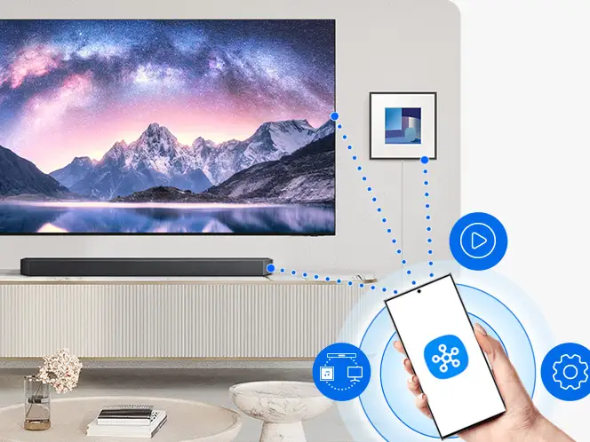 Smartfon z aplikacją SmartThings połączony przez Wi-Fi (Wireless Fidelity) z telewizorem i soundbarem Samsung HW-Q990H.