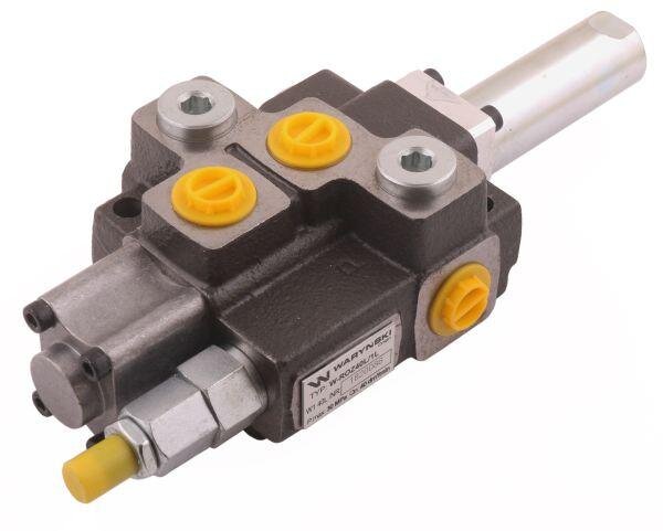 Na obrazie znajduje się metalowy rozdzielacz hydrauliczny z żółtymi elementami i etykietą z napisem \'Waryński\'.