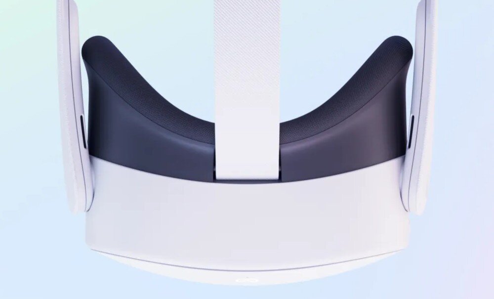 Na obrazie widoczne są gogle VR w kolorze białym z czarnymi elementami, z paskiem na głowę. Na dolnej części gogli znajduje się logo \'meta\'.