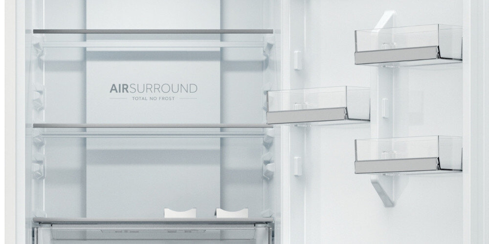 Wnętrze lodówki z półkami i szufladami na drzwiach. Widoczny tekst: \'AIR SURROUND TOTAL NO FROST\'.