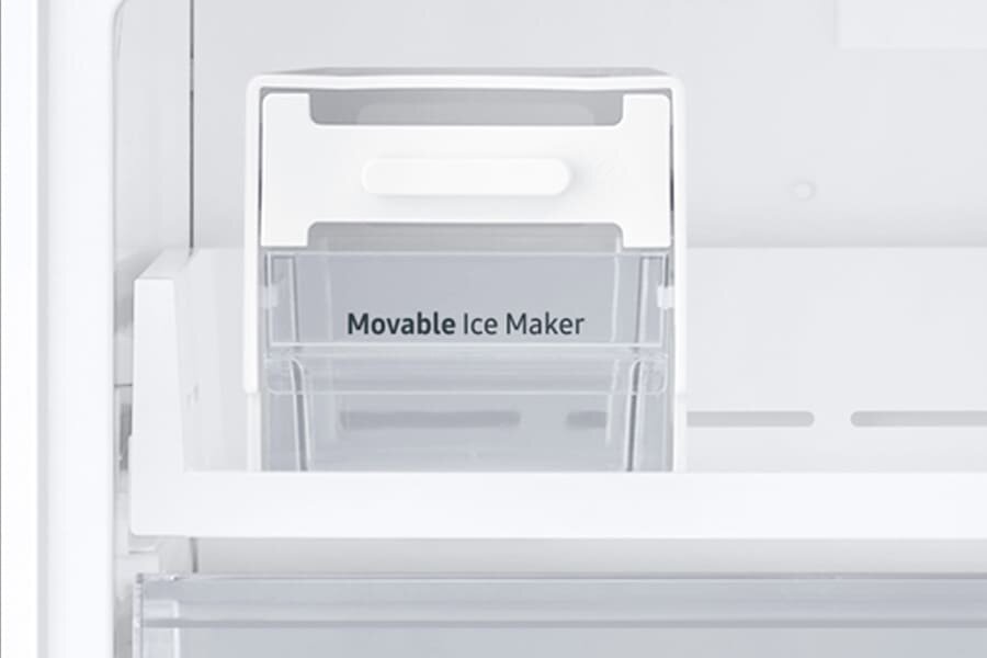 Wnętrze lodówki z widocznym przezroczystym pojemnikiem na lód z napisem \'Movable Ice Maker\'. Pojemnik ma biały uchwyt na górze.