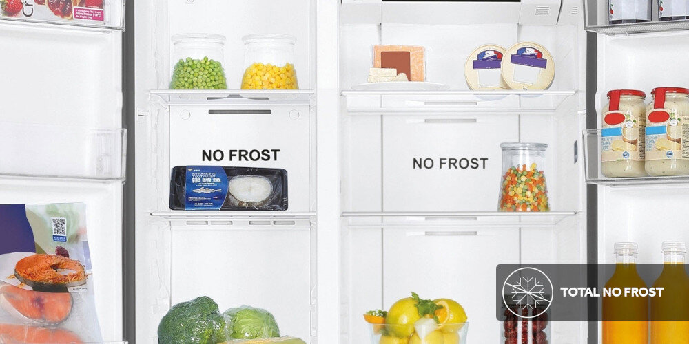 Wnętrze lodówki z napisem \'NO FROST\' na dwóch półkach, wypełnione różnymi produktami spożywczymi, takimi jak warzywa, owoce, sery i napoje. W prawym dolnym rogu widoczne jest logo z napisem \'TOTAL NO FROST\'.