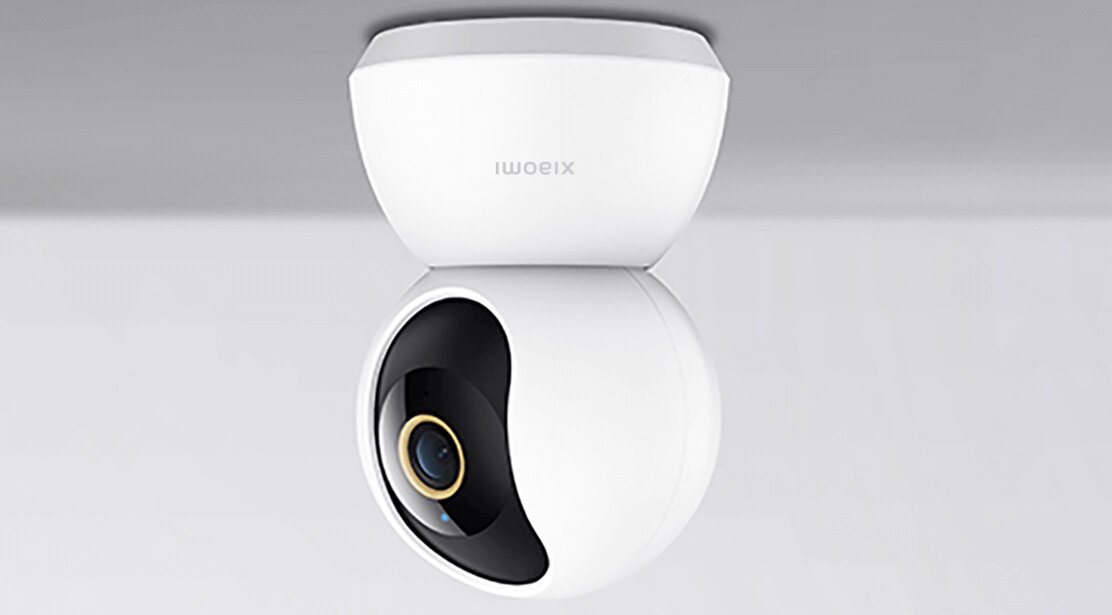 Biała, obrotowa kamera z czarnym obiektywem i złotym pierścieniem. Na obudowie widoczne jest logo \'xiaomi\'.