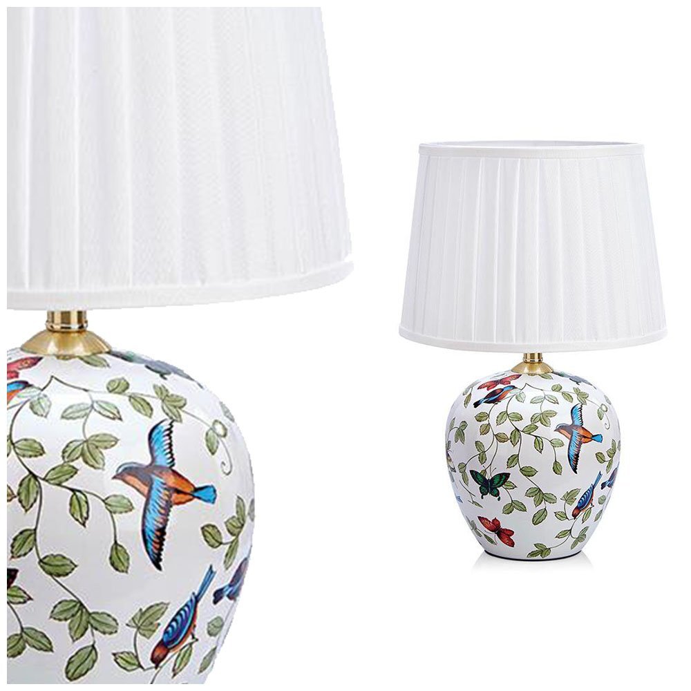 Lampa stołowa z białym abażurem i ozdobną podstawą z motywem kolorowych ptaków i liści. Produkt przedstawiony na białym tle.