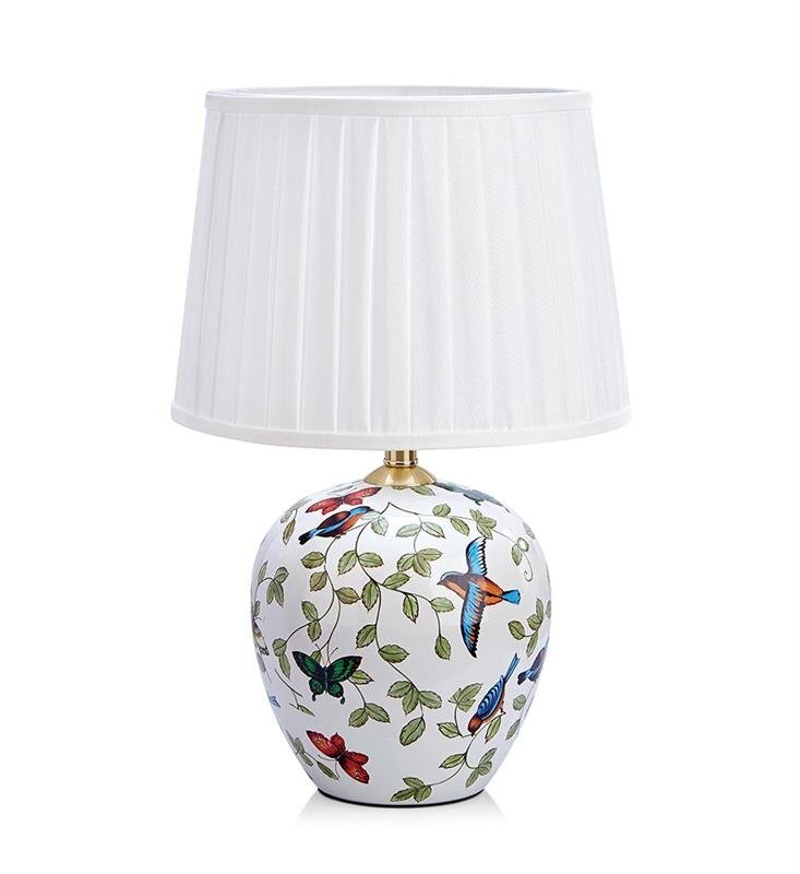 Lampa stołowa z białym, plisowanym abażurem i ceramiczną podstawą ozdobioną kolorowymi motywami roślinnymi i ptakami. Podstawa ma kształt zaokrąglonego wazonu.